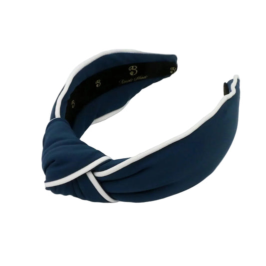 Navy blue headband with white trim on a light gray background