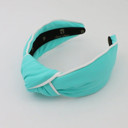 Turquoise headband with white accent on a light gray background